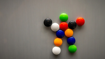 Stickman emoji using the colorful fridge magnet on the refrigerator.