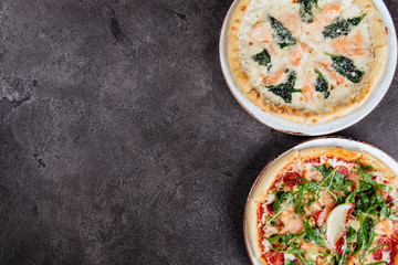 Traditional Italian pizza on a dark background top view copy space.