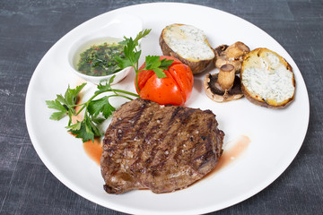 Beef steak with chimichurri sauce and vegetables.