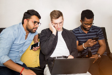 Fototapeta premium Group of friends sitting on sofa with laptop