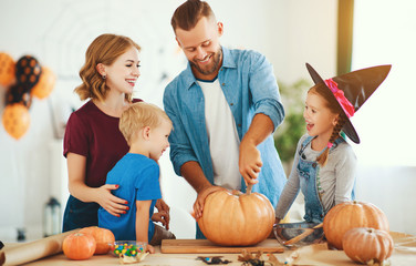 Fototapeta premium happy Halloween! family mother father and children cut pumpkin for holiday at home..