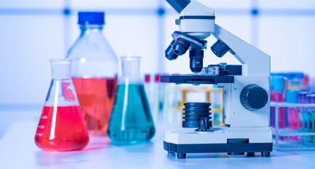 scientific experiment in school class. Microscope and test tubes on the table