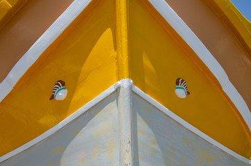 Front view of colorful painted wood boat with the typical protective eyes in Marsaxlokk, Malta.