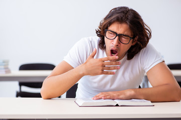 Young male student sitting in the classroom