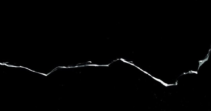 Shattered and broken glass shards flying through the air after crush broken window on a black background