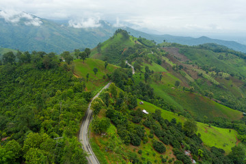 Fototapeta na wymiar Aerial view of cars driving curves on the mountains and beautiful roads suitable for holiday travel in Nan Province, Thailand.
