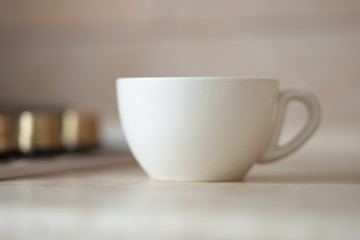 Fototapeta na wymiar Blank white mug on kitchen work surface.
