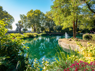 Beautiful landscape in fall season with orange and yellow forest reflected in emerald lake inside Bishops park in Fulham area - London