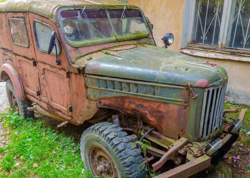 A rusty old car, abandoned years ago.