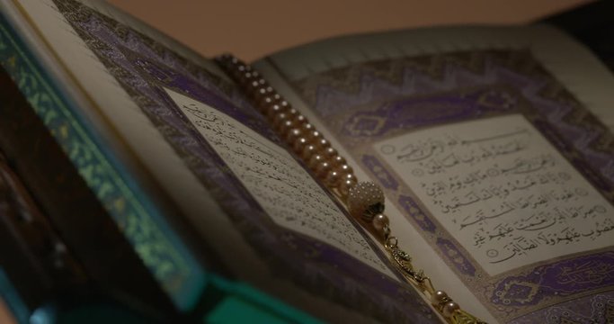 Holy Quran on Book Rest with Prayer Beads Close Up Rotation 3 Loop