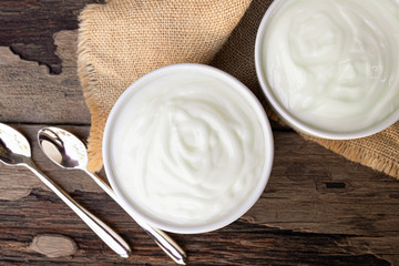 Yogurt white put in a glass put on a wooden background from top view.