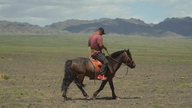Ulaanbaatar / Mongolia, May, 5,2019: a Mongolian rider a shepherd on a horse rides in the foothills of Mongolia