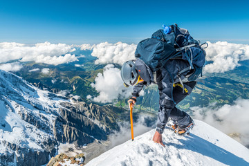 Extreme alpinist in high altitude on Aiguille de Bionnassay mountain summit, Mont Blanc massif, Chamonix, Alps, France, Europe