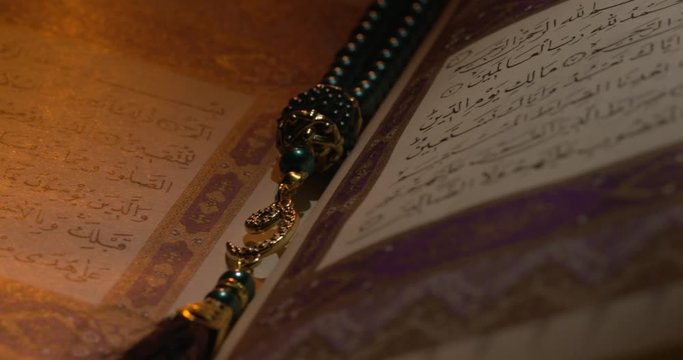 Holy Quran on Book Rest with Prayer Beads Close Up Rotation 10