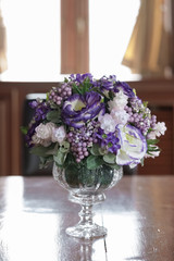 Vintage flowers. Vintage flowers for interior decoration. Fake purple and white roses and other flowers in the dining table.