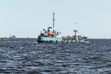 A small transport ship goes into the harbor.