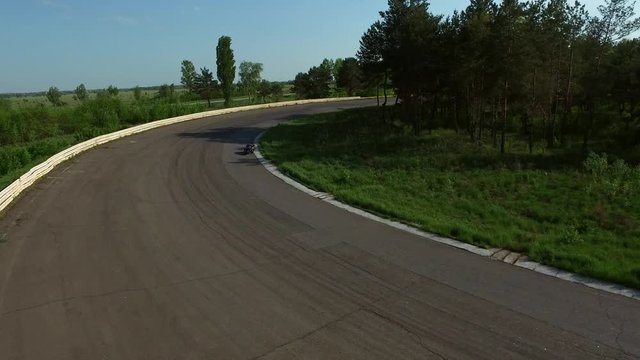 Drone view motorcycle rider driving on racing track. Aerial view moto riding
