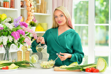 Portrait of beautiful young woman cooking in kitchen