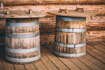 Fototapeta premium wooden barrels next to a wooden log house