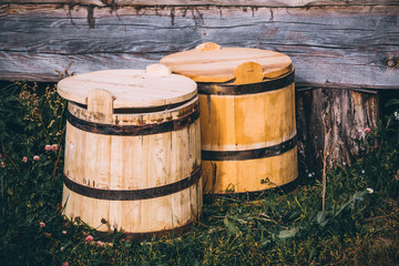 wooden barrels next to a wooden log house