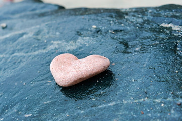 Fototapeta premium Heart of stone. Sea stone texture. Panel texture. Spots gray red background. Background fill. Natural stone background.