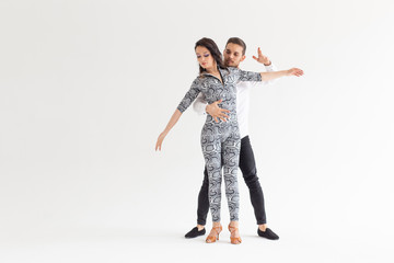 Obraz na płótnie Canvas Social dance, bachata, kizomba, zouk, tango concept - Man hugs woman while dancing over white background with copy space