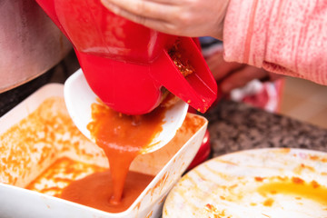 Making Tomato Sauce on the Stove. A close up of the hand mill griinding up the fresh field tomatoes...