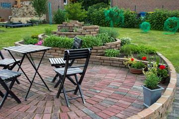 herb spiral in the garden with herbs and flowers