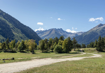 Mountain road in a panorama of a sunny mountain valley