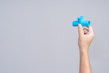 Hand holding three ways pvc water pipe