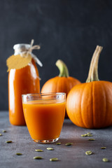 Pumpkin smoothies and other ingredients on a dark wooden background.