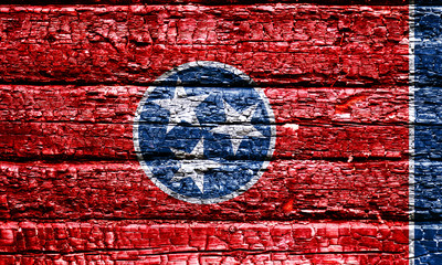 The national flag of the US state Tennessee in against a black charred wooden wall on the day of independence. Political and religious disputes, fire department and firefighters.