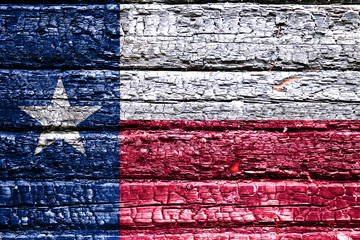 The national flag of the US state Texas in against a black charred wooden wall on the day of independence. Political and religious disputes, fire department and firefighters.