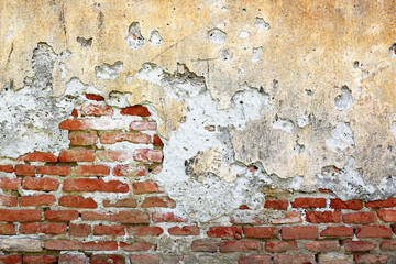 cracked plaster layer on brick wall