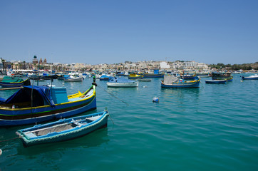 Fototapeta na wymiar Traditional maltese painted boats at the Marsaxlokk bay