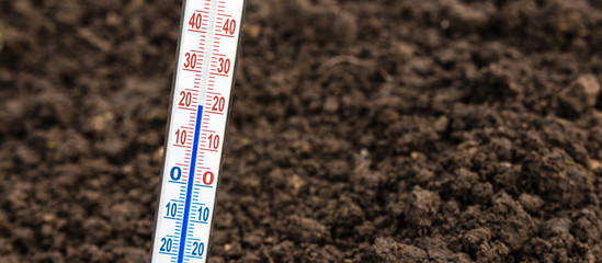Thermometer for measuring soil temperature for gardening and planting plants against the background...