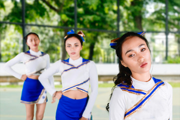 Beautiful cheerleader team performing in the field