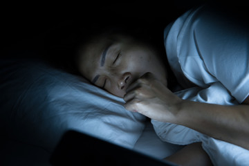 Asian woman play smartphone in the bed at night,Thailand people