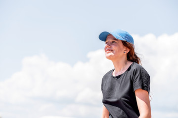 Young caucasian woman in summer clothes looking away on blue sky background