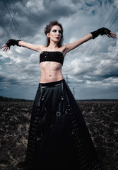 Informal fashion: beautiful slender young gothic girl dressed in black leather skirt and gloves....