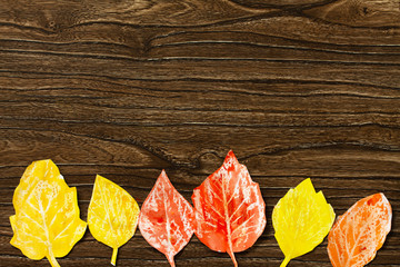 Autumn background. Candle and watercolor paint to create autumn leaves on wooden background. Crafts from paper for children. Children's art project. Top view flat lay. Free space for your text.