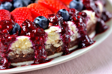 Detail of plate with cake with fresh strawberries, blueberries and cherry jam.