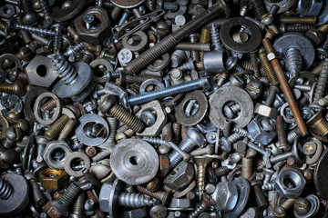 Abstract background with various screws, nuts, bolts and washers and other fasteners. Macro.