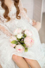 delicate bouquet in the hands of a girl in a white peignoir