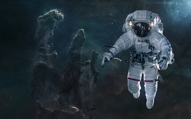 Obraz premium Astronaut on background of the Pillars of Creation. Deep space landscape. Science fiction. Elements of this image furnished by NASA