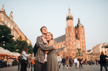 Fototapeta Young loving couple hugs at central square in Krakow (Cracow). obraz