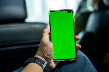 Male passenger holds a phone with green screen