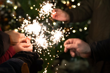 Group of friends burning Bengal lights during winter time celebrations, Christmas, New Year's Eve.