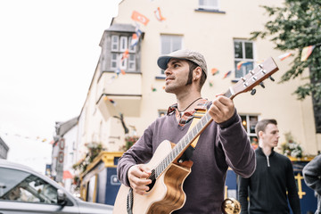 Fototapeta na wymiar Street performer man playing the guitar