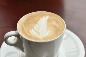 Coffee cup latte art on wooden table background.frothy milk texture on arabica coffee for coffee break time.
